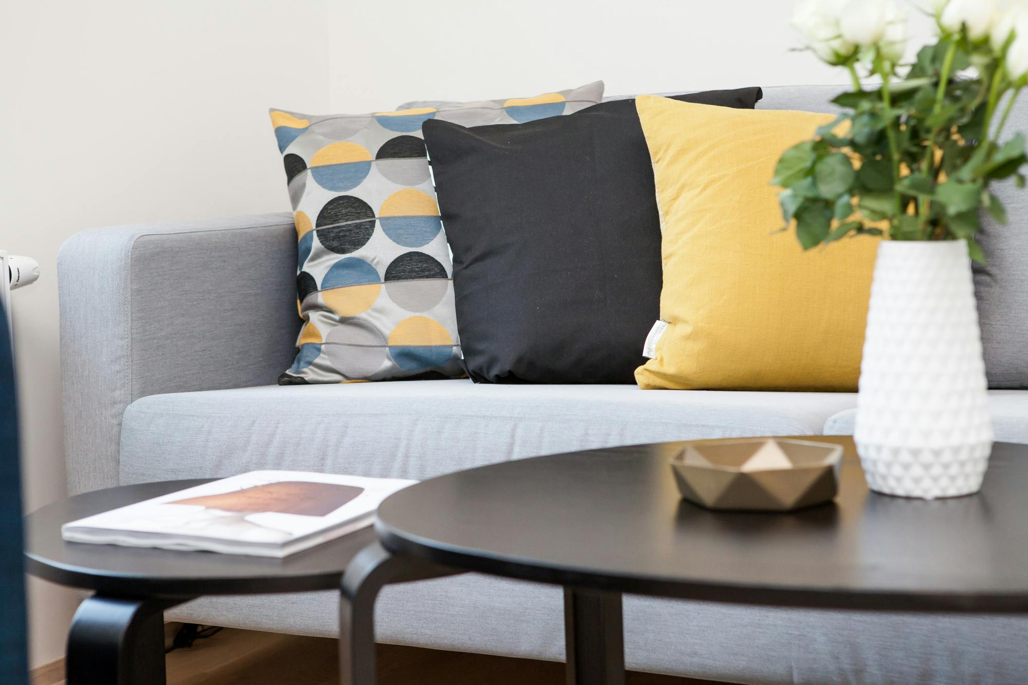 sofa with three different coloured pillows adorned with a coffee table